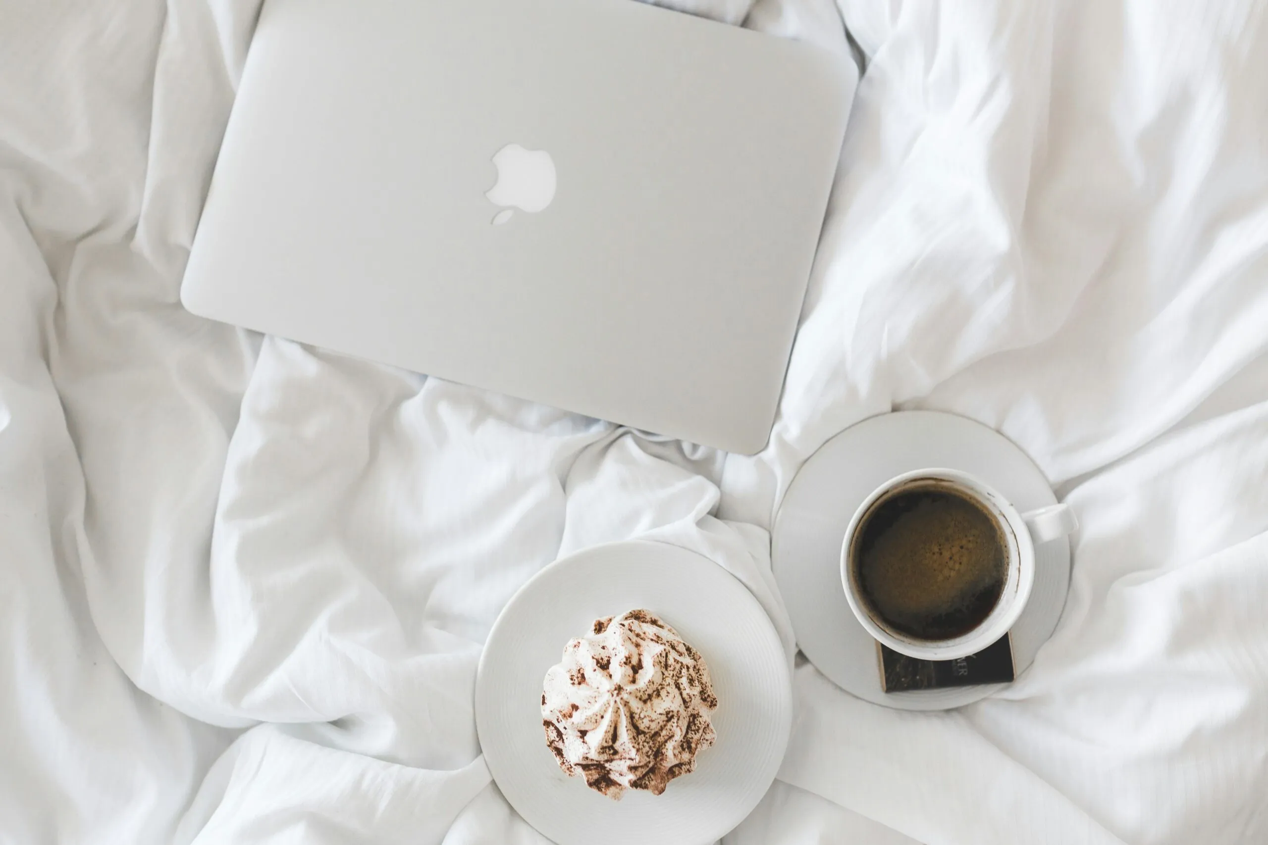 Koffie en gebak op wit beddengoed